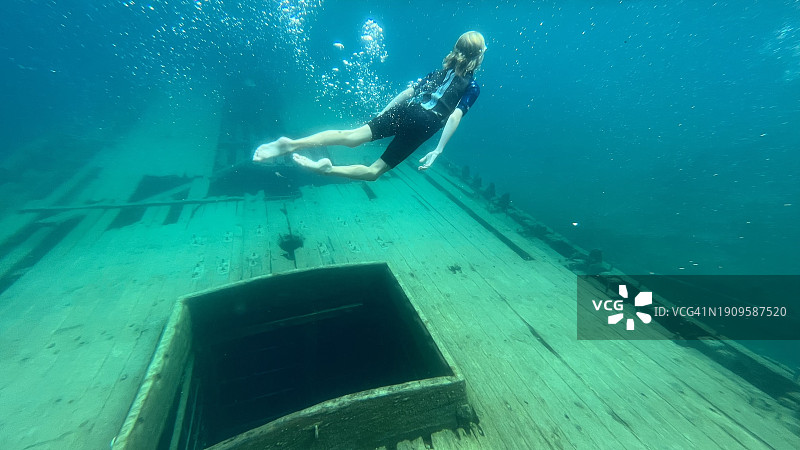 在加拿大安大略省托伯莫里五噚海洋国家公园大浴缸港，赤脚自由潜水员探索Sweepstakes纵帆船沉船图片素材