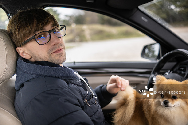 男人和他的毛茸茸的朋友在开车时是最好的伙伴图片素材
