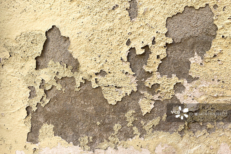 墙上旧油漆形成的背景纹理，混凝土灰泥墙上的黄色油漆剥落图片素材