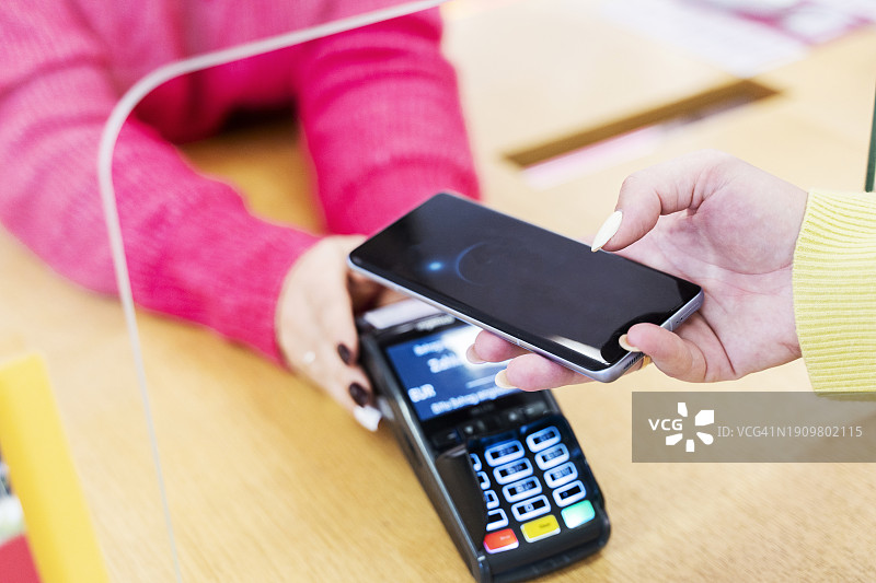 女人用智能手机支付图片素材