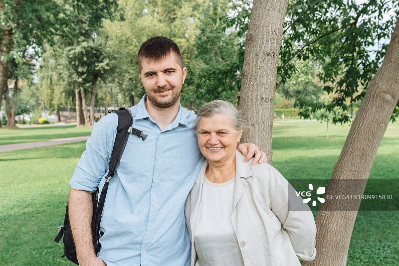 在公园里和年长母亲在一起的成熟男人肖像图片素材