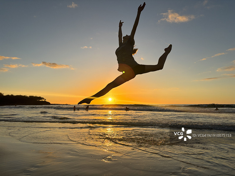夏威夷哈普纳海滩州立游乐区，在沙滩上夕阳下跳舞的年轻女性剪影图片素材
