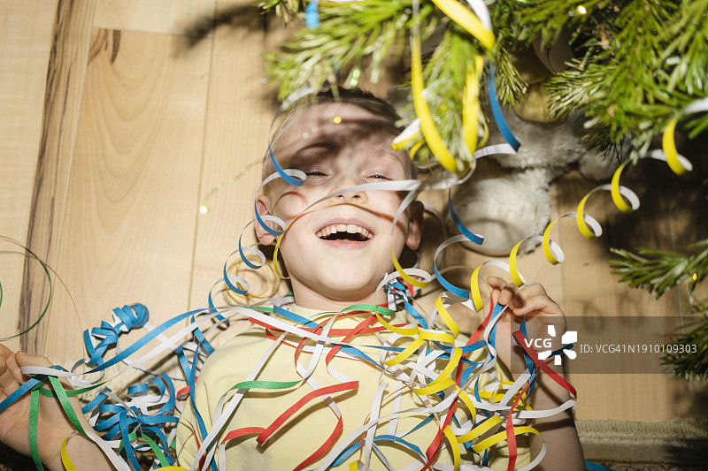 快乐的男孩在家玩派对礼炮图片素材