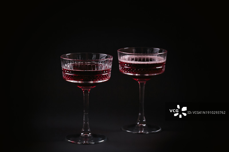 黑色背景上的两杯红色气泡酒图片素材