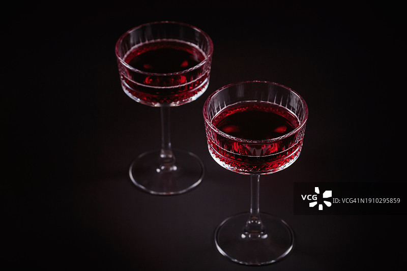 黑色背景上的两杯红色气泡酒图片素材