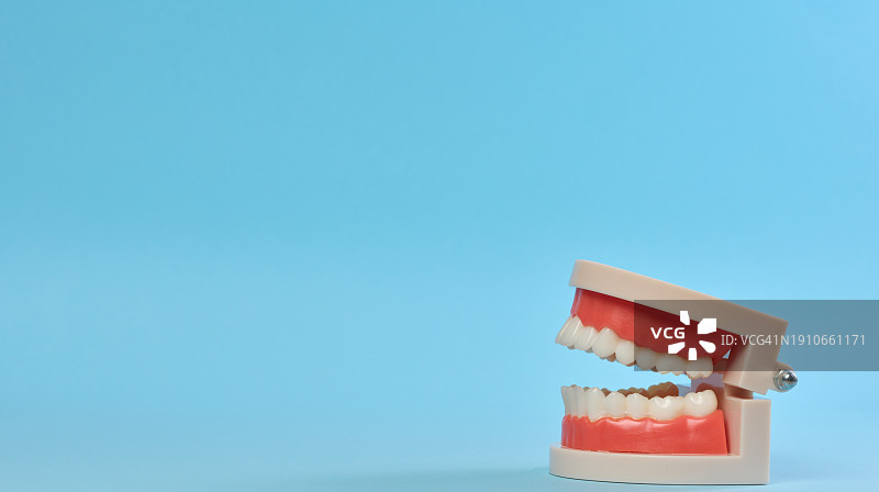 蓝色背景下的假牙特写图片素材