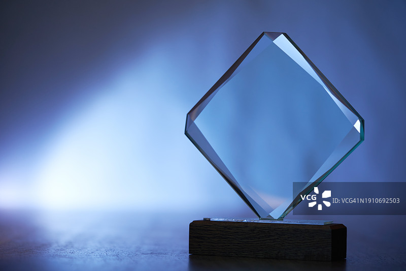蓝色背景下桌子上的奖杯特写图片素材