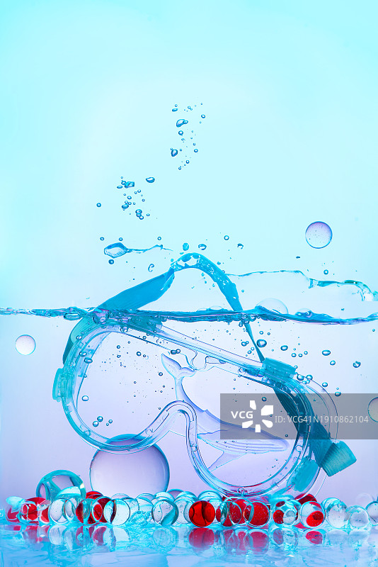 蓝色水下静物游泳镜与水花图片素材