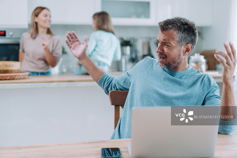 父亲在家工作，孩子在一旁打扰图片素材