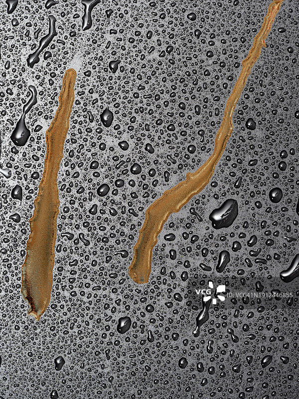 金色金属液体滑过湿润表面，带有小水滴图片素材