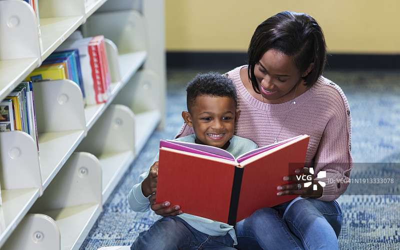 非洲裔母亲和儿子在图书馆阅读图片素材