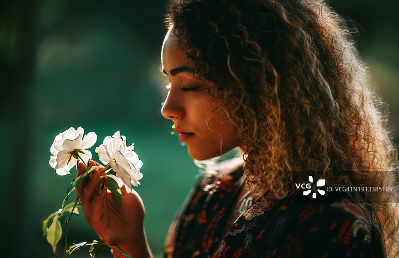 呼吸玫瑰的美丽年轻女子图片素材