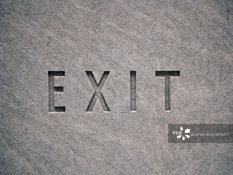 美国纽约曼哈顿灰色石墙上刻着大写字母“EXIT”。阳光，自然色图片素材