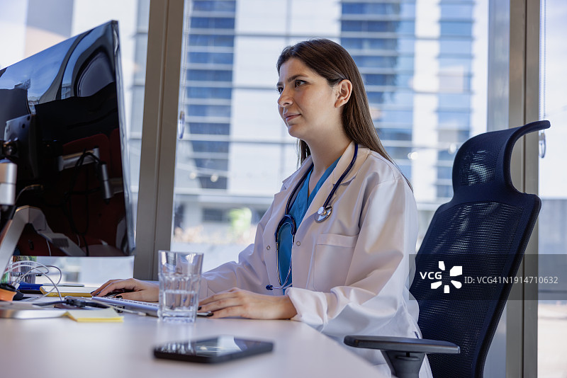 女医生在台式电脑上查看病人记录图片素材