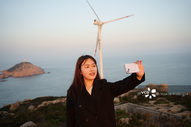 年轻女子在海滩拍照图片素材