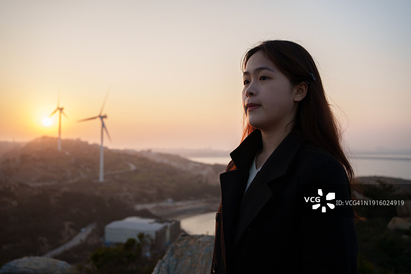 在山上观看日落的年轻女人图片素材