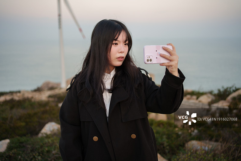 女游客用智能手机拍照图片素材