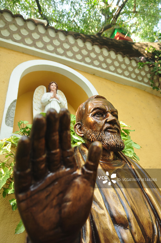 圣比约雕像的低角度特写，雕像的手在前景中图片素材