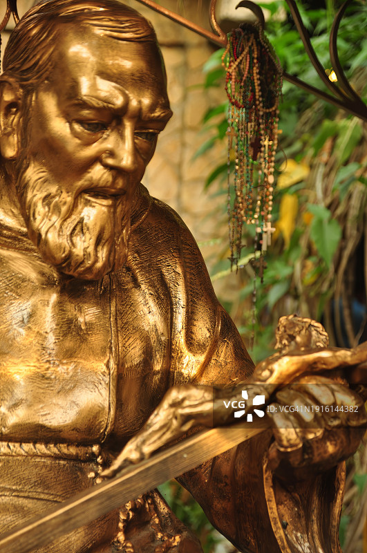 手持十字架的Padre Pio青铜雕像特写图片素材