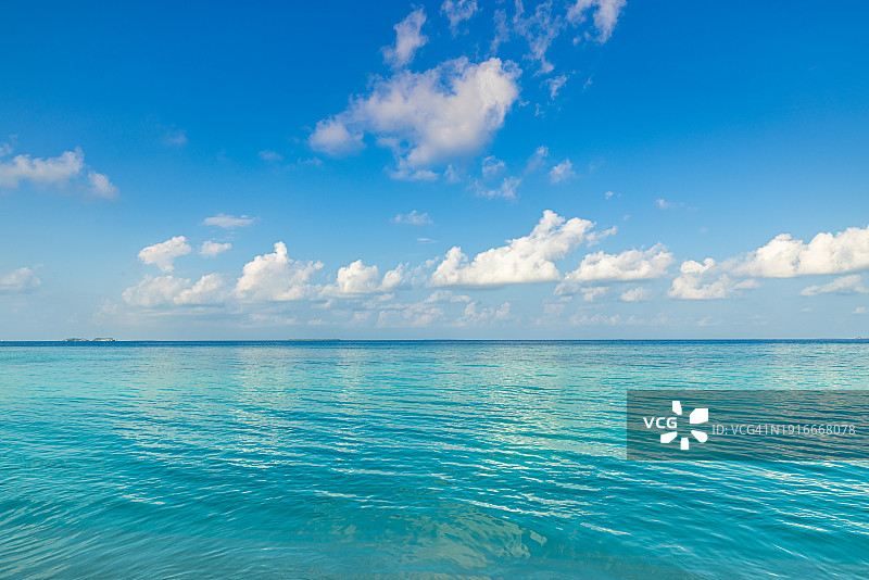 阳光明媚的蓝天碧海，平静的海湾，祥和的海浪，世界环境日概念，令人放松的云彩海景，旅游岛屿海岸，海滩风光，平静的水面地平线图片素材