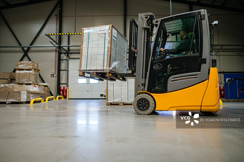 仓库内工作的叉车特写：工业升降卡车在现代工厂搬运物料，带文案空间的仓库banner图片素材