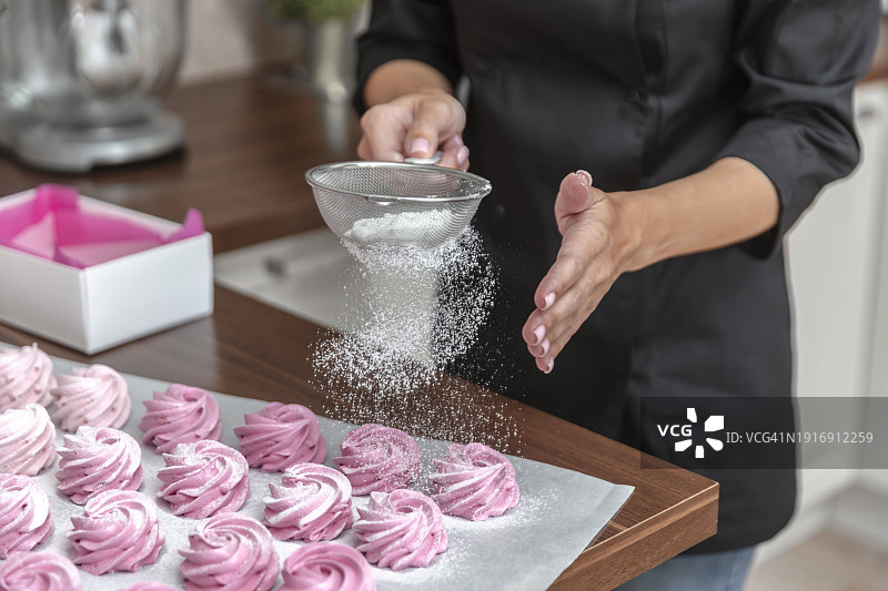 女人在棉花糖上筛糖粉图片素材