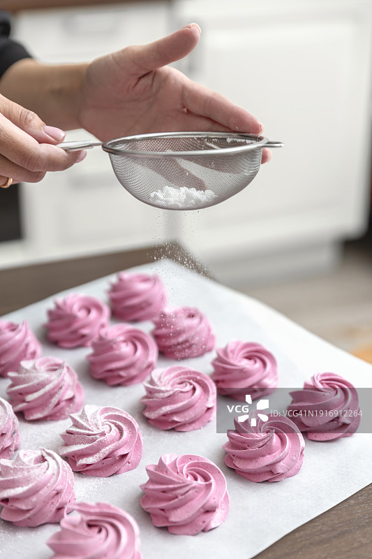 女人在棉花糖上筛糖粉图片素材