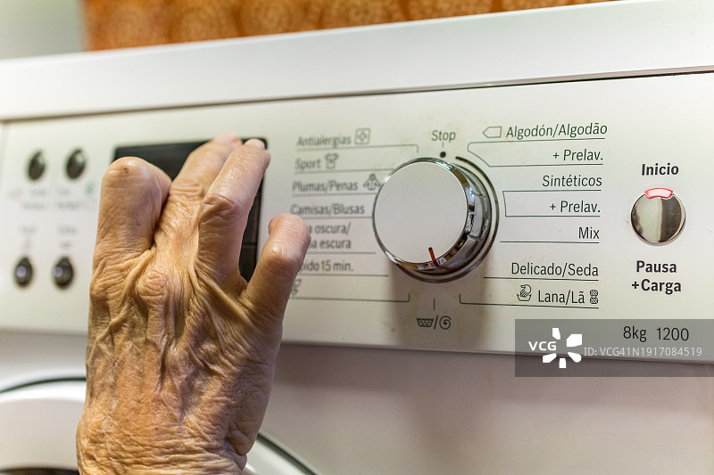 年长的女人打开洗衣机图片素材