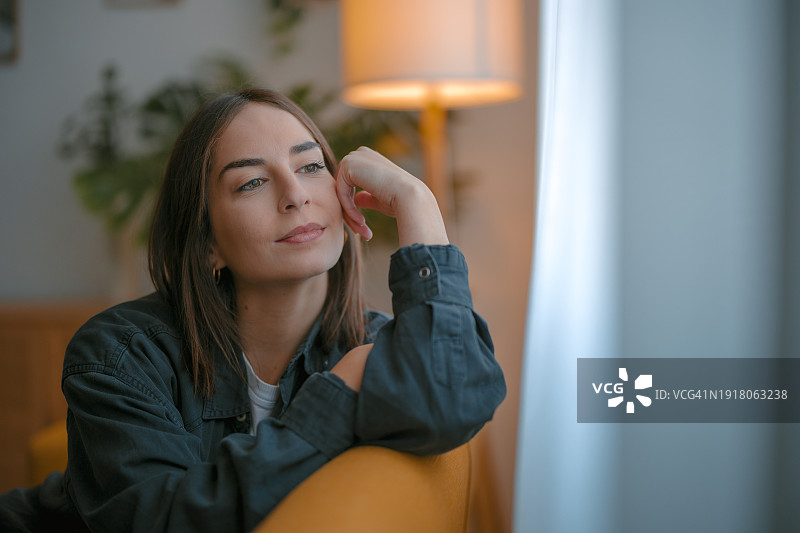 美丽的女人看着窗外图片素材