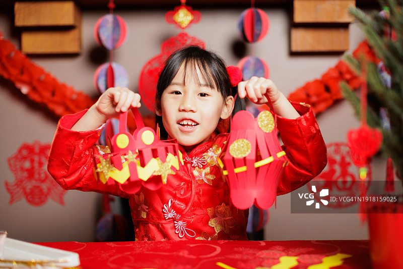 身穿传统服饰在家庆祝中国新年的年轻中国女孩图片素材