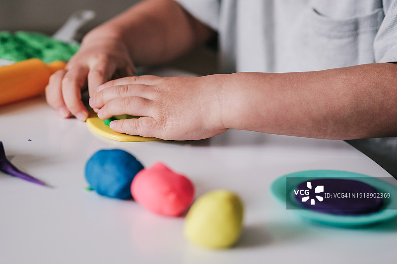 在家玩橡皮泥的幼儿男孩图片素材