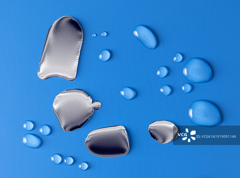 银色金属液滴滑落湿润蓝色背景小水珠图片素材