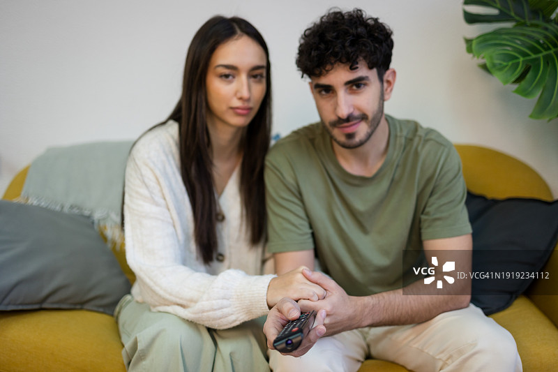 年轻夫妇在沙发上看电视图片素材