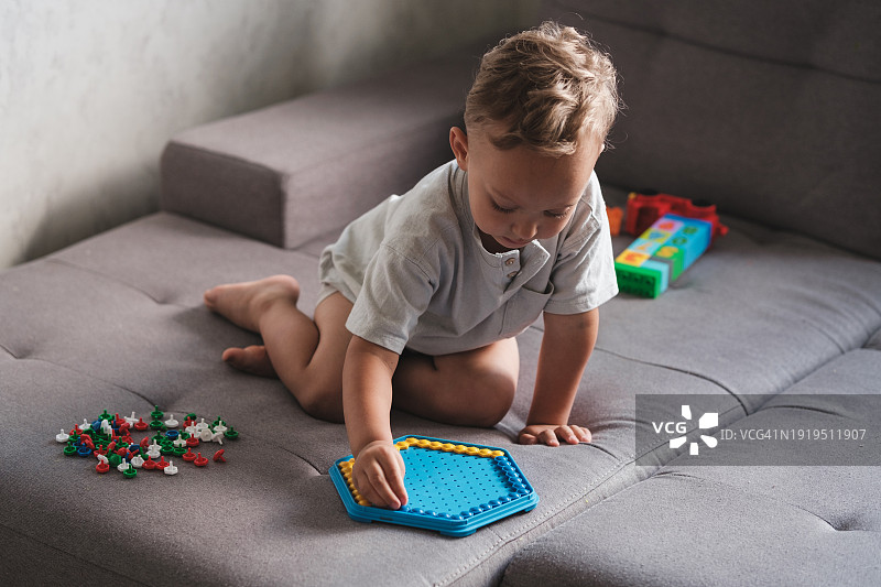 小男孩在家玩拼板玩具，儿童感官游戏，培养创造力和精细运动技能图片素材