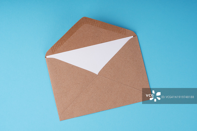 蓝色背景上的棕色信封和纸条图片素材