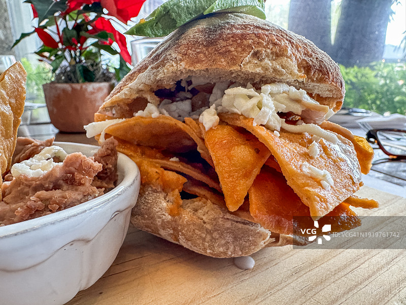 美味的奇拉基莱三明治或墨西哥薄饼，配奶酪、鳄梨和一份带有玉米饼的炒豆泥，墨西哥早餐 - 墨西哥城，墨西哥图片素材