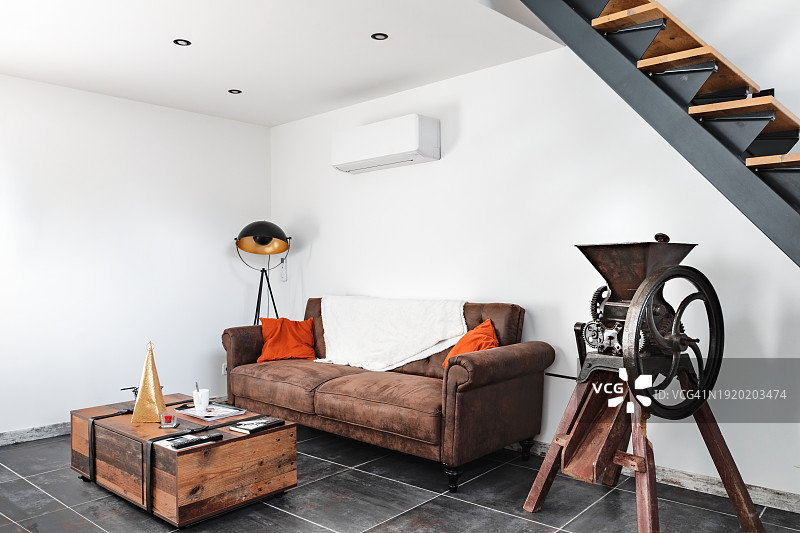装饰精美的舒适阁楼客厅，现代楼梯下设有沙发图片素材