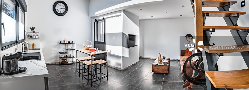 舒适明亮的开放式阁楼内部广角图，设有夹层、厨房和客厅图片素材