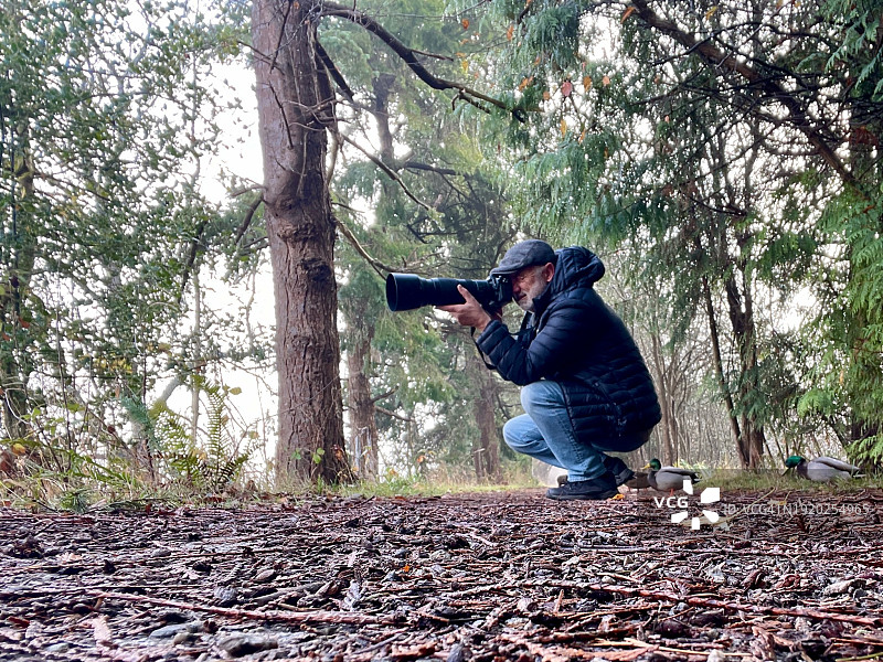 男子在不列颠哥伦比亚省温哥华的乡村用长焦镜头相机拍照图片素材