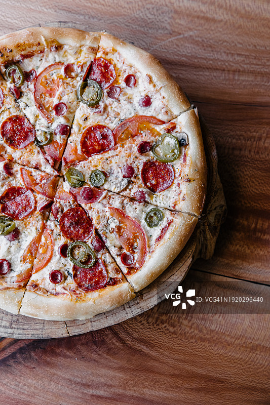 木板上的萨拉米番茄披萨特写图片素材