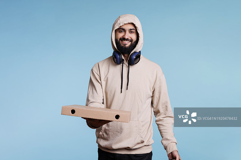 微笑的阿拉伯快递员拿着披萨盒图片素材