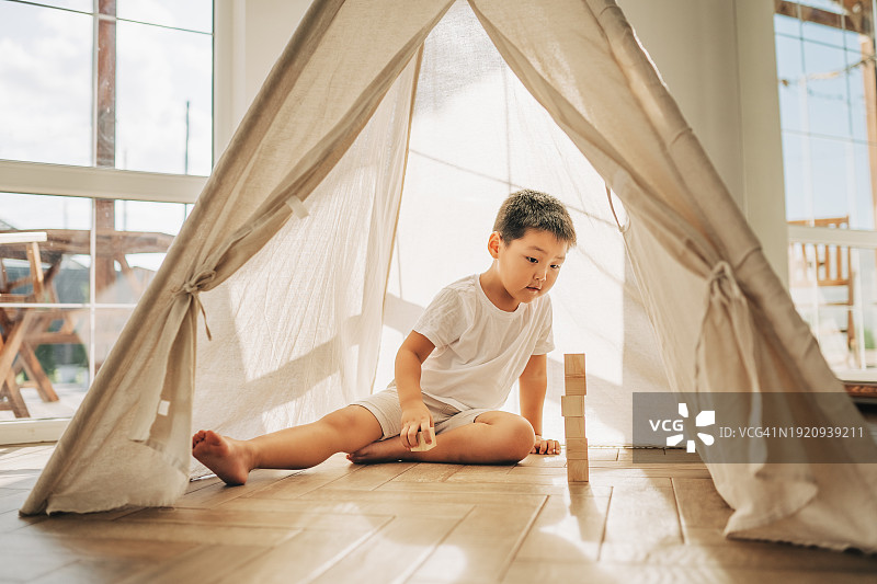 在帐篷里玩骰子的亚洲男孩图片素材