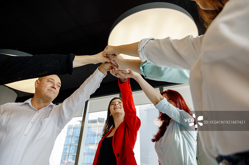 团结的愿景：商业伙伴在创意豪华办公室环境中携手合作，培养团队精神图片素材