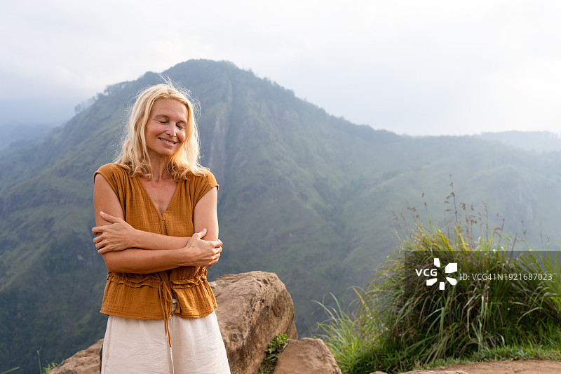 女人在山中拥抱自己，正念冥想图片素材