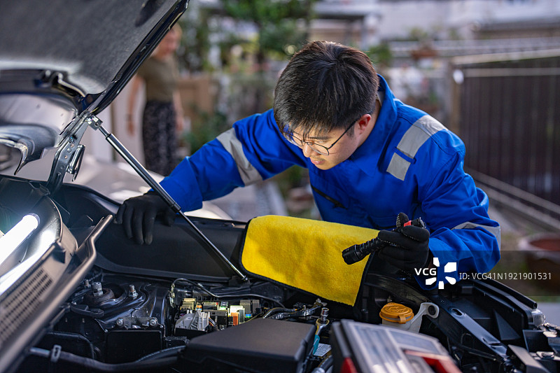 自信的汽车维修技师在自家车库工作图片素材