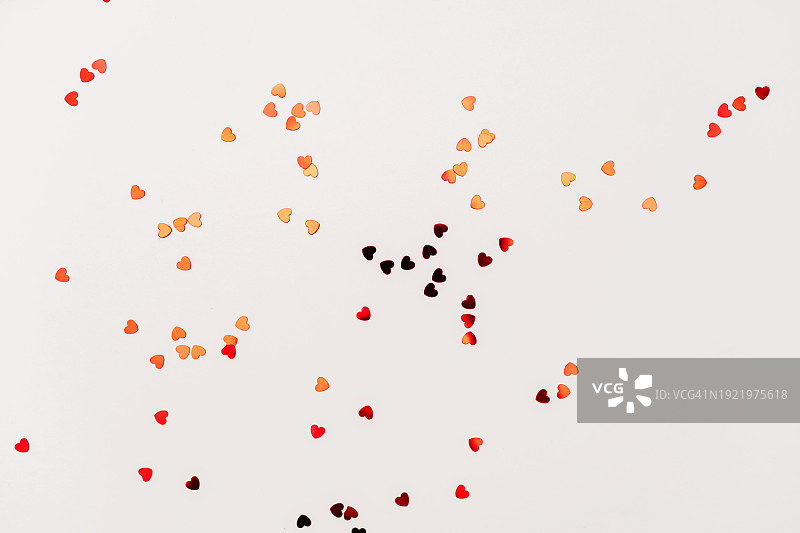 情人节鲜花构图。玫瑰花和纸屑组成的圆形框架在白色背景上。情人节背景。平铺，顶视图，复制空间。图片素材