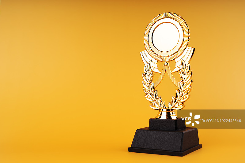 黄色背景上的金色奖杯图片素材