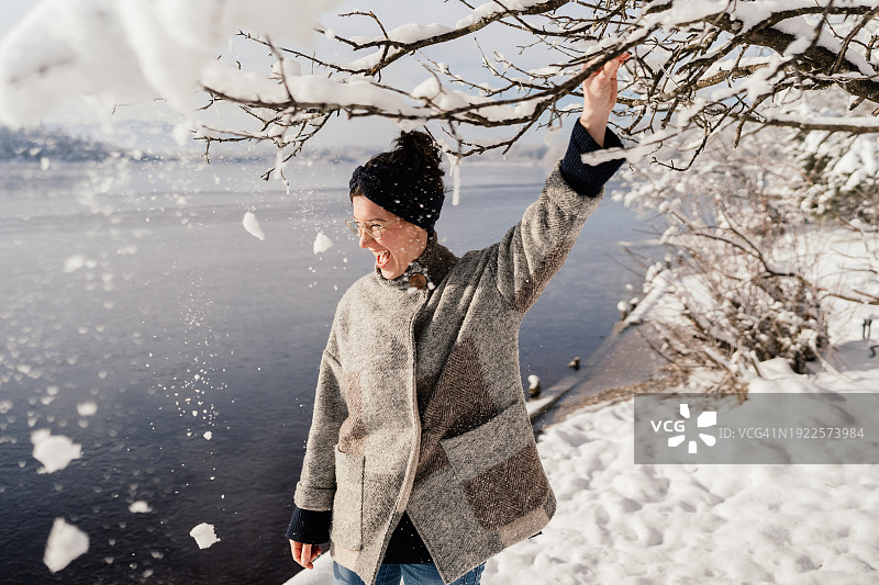 在冬日湖边玩雪欢笑的女人图片素材