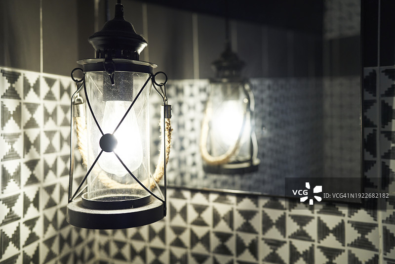 浴室天花板上悬挂的灯的侧视图，墙上有镜子，没有人图片素材