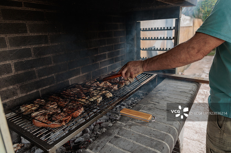男人在希腊烤肉架上烤肉图片素材